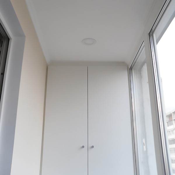 Белый шкаф встроенный в нишу на балконе сложной формы вид 2